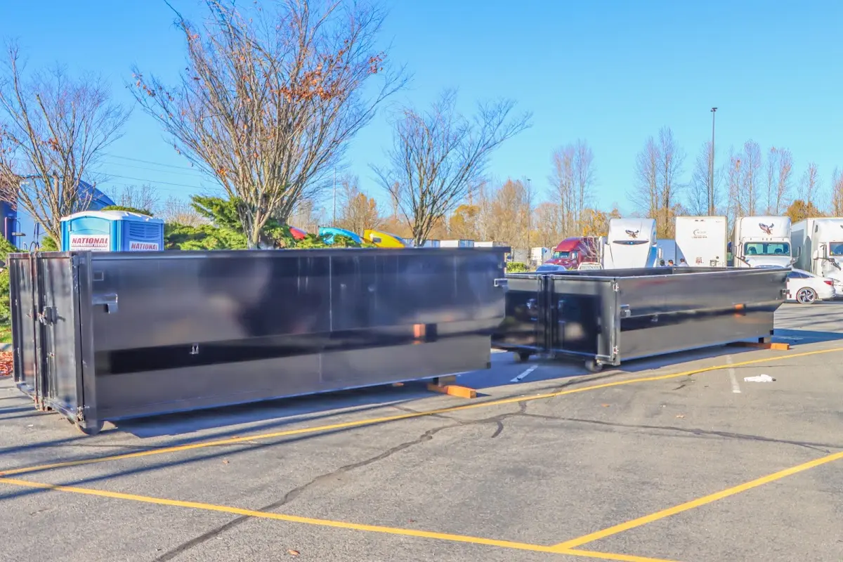 Professional dumpster rental service with roll-off container on residential driveway in Phelps